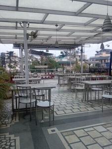 a patio with tables and chairs under a pavilion at Hotel Anmol in Dehradun