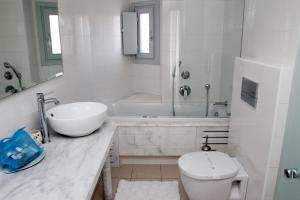 a bathroom with a sink and a toilet and a tub at San Marco Hotel and Villas in Houlakia