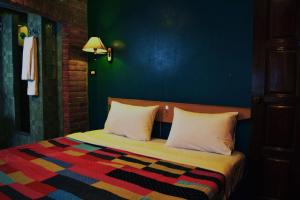 Un dormitorio con una cama con una manta de colores. en BRICKHOUSE Ayutthaya Guesthouse EST 1986, en Phra Nakhon Si Ayutthaya