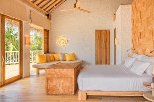 a bedroom with a bed and a balcony at Soneva Fushi in Baa Atoll