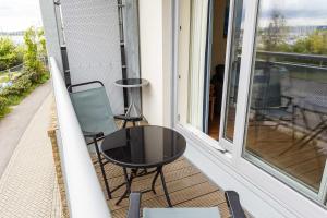 a balcony with two chairs and a table and a window at Coxswain's Cabin - Moments from Hamworthy Beach and Park in Poole