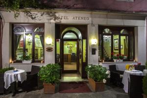 einen Hoteleingang mit Tischen und Stühlen vor einem Gebäude in der Unterkunft Hotel Ateneo in Venedig