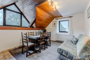 a dining room with a table and chairs and a couch at Apartments Mija in Krotica