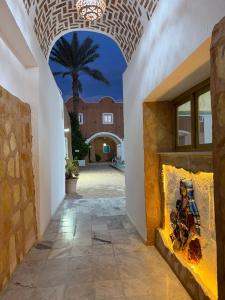 a room with a fireplace with a palm tree in the background at Hotel Matmata in Matmata +14 photos
