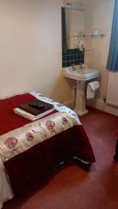 a bedroom with a bed and a sink and a sink at Banbury Cross B&B in Banbury +110 photos