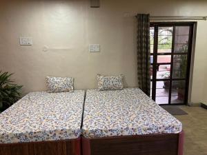 a bedroom with a bed with pillows on it at Umang Homestay in Talegaon Dābhāde +3 photos