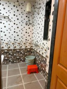 a bathroom with a toilet and a wall with dots at Umang Homestay in Talegaon Dābhāde