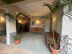 a patio with two palm trees and a bench at Umang Homestay in Talegaon Dābhāde