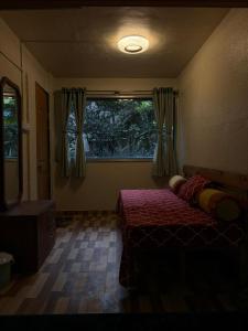a bedroom with two beds and a window at Umang Homestay in Talegaon Dābhāde
