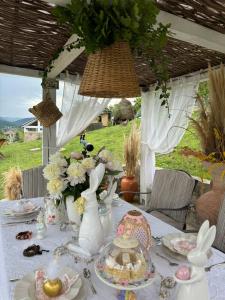 a table with vases and plates of food and flowers at Dream Tricule in Sviniţa