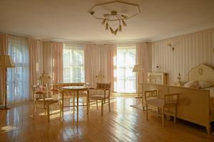 a living room with a table and chairs and a bedroom at Pałac Brzeźno Spa & Golf in Oborniki Śląskie