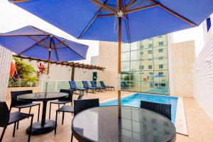 a patio with tables and umbrellas and a pool at Go Inn Hotel Aracaju in Aracaju +35 photos