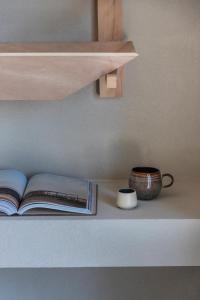 a book on a shelf with a cup and a bowl at K Studios in Faliraki