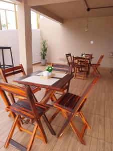 a group of wooden tables and chairs in a room at Pousada Serra do Torreão in João Câmara