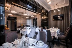 a restaurant with white tables and chairs and a tv at Wall Street - Maestro in Odesa +49 photos