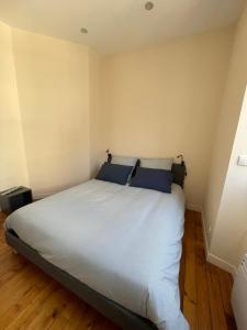 a bedroom with a large white bed with blue pillows at Maison de ville in Lannion