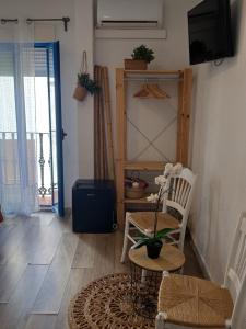 a living room with a table and chairs and a television at Ananda Beach Rooms - Castillo de Peñiscola in Peniscola