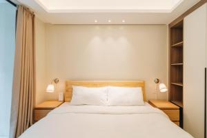 a bedroom with a white bed with two night stands at Dragon's Keep BNB near NAIA and MOA in Manila