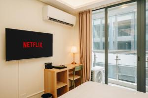 a hotel room with a netflix sign on the wall at Dragon's Keep BNB near NAIA and MOA in Manila