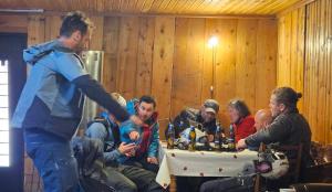 a group of people sitting around a table with food at Guest House Buba in Ushguli