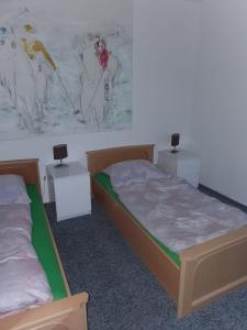 two beds in a room with a painting on the wall at Ferienwohnung zur Apotheke in Hessen
