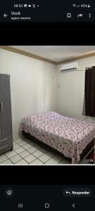 a bedroom with a bed with a floral blanket at Solares Residence in Teresina