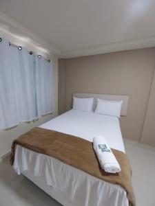 a bedroom with a large white bed with two pillows at Pousada Serra do Torreão in João Câmara