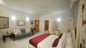 a large bedroom with a bed and a couch at Four Squares by WIH in Karachi