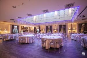 a banquet hall with white tables and chairs at Savoia Hotel Regency in Bologna