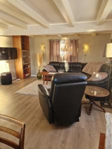 a living room with leather chairs and a couch at Vareid Panorama Lofoten Vareidstua in Vareid