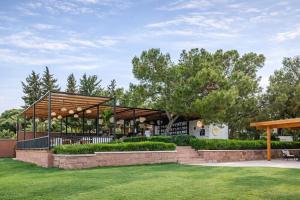 a pavilion with a table and chairs in a park at Rai Foresta Tekirova & SPA in Kemer