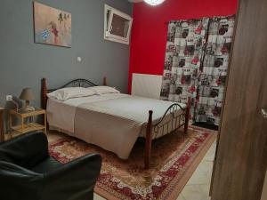 a bedroom with a bed and a chair at Magda's apartments in Perea