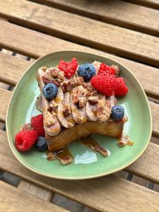a piece of toast with fruit on a green plate at Dom z widokiem na Wisłę, ogrodem i parkingiem AC Progres in Toruń +27 photos