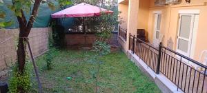 a garden with an umbrella on the side of a house at Magda's apartments in Perea