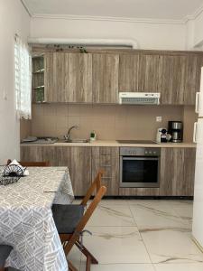 a kitchen with wooden cabinets and a table and a table and a table at Sunny Beachfront Apartment in Nerántza