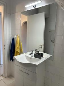 a bathroom with a white sink and a mirror at Sunny Beachfront Apartment in Nerántza +20 photos