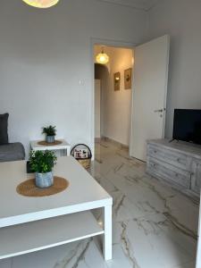 a living room with a white table and a television at Sunny Beachfront Apartment in Nerántza