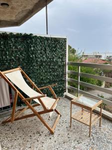 a chair and a table on a balcony at Sunny Beachfront Apartment in Nerántza