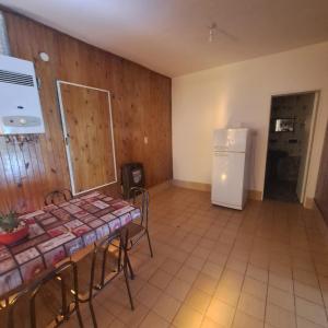 a kitchen with a table and a white refrigerator at La Tia in Alta Gracia