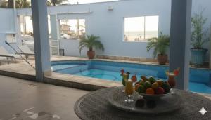 a bowl of fruit on a table in front of a pool at casa azul in Itanhaém