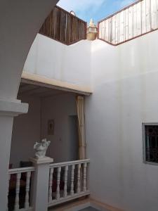 a staircase in a white house with a balcony at RIAD Adam in Sidi Ifni +5 photos
