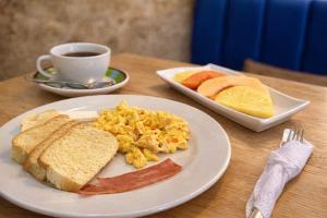 a table with a plate of breakfast food and a cup of coffee at Hotel Getsemaní Central in Cartagena de Indias