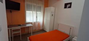 a small room with an orange chair and a white refrigerator at B&B SICILIA in Messina