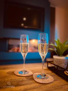 two glasses of champagne sitting on a table at Barneys Retreat - Lakeside Getaway in South Cerney