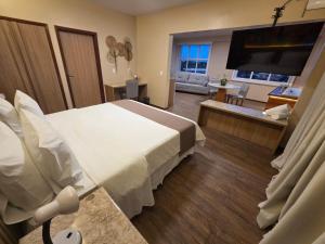 a hotel room with a bed and a living room at Hotel São Francisco in Penedo +61 photos
