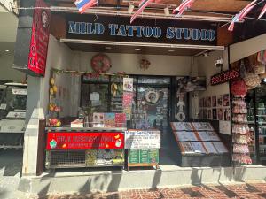 a guided tattoo shop with a sign on the front of it at MILD ISLAND STAY ROOm in Phi Phi Islands