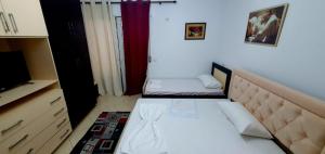 a small room with two beds and a tv at Apartament martin 3 in Vlorë