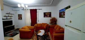 a living room with two chairs and a refrigerator at Apartament martin 3 in Vlorë
