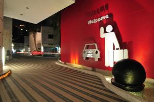 a room with a red wall with a picture of a person and a car at 168 Motel-Taoyuan in Taoyuan