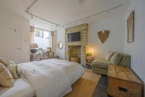 a bedroom with a bed and a couch and a table at New The Barley Rustic luxury in Cirencester